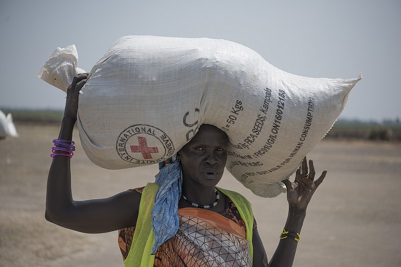 
              In this photo taken Tuesday, April 11, 2017, A woman walk back to her home after receiving food distributed by ICRC at a site in Leer County region of South Sudan. Two months after a famine was declared in two counties amid its civil war, hunger has become more widespread than expected, aid workers say, region on the brink of starvation and people at risk of dying without sustained food assistance. (AP Photo)
            
