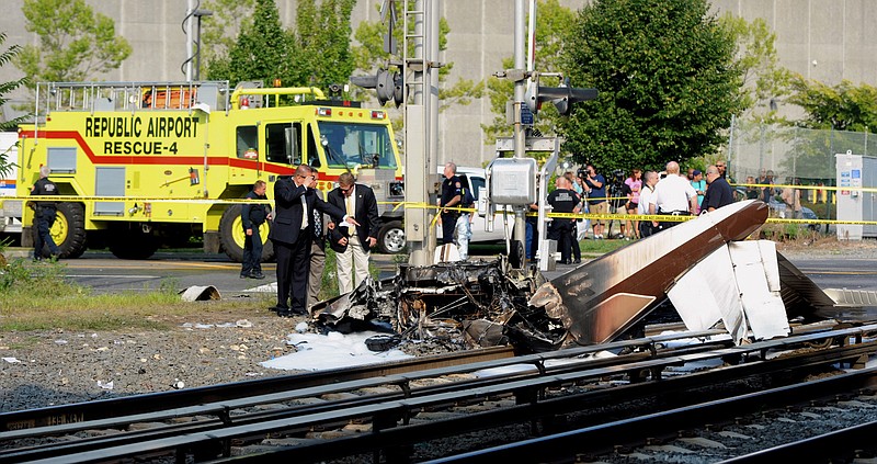 
              FILE- In this Aug. 16, 2015 file photo, investigators examine the scene where one person died and another was injured in the crash of a single-engine plane on Long Island Rail Road tracks on the line between Bethpage and Hicksville, NY. As a result of this crash, the Federal Aviation Administration now regularly check the accuracy of its radar video maps after an air traffic controller directed the pilot with engine trouble to a closed airport moments before the plane went down. (James Carbone/Newsday via AP, File)
            