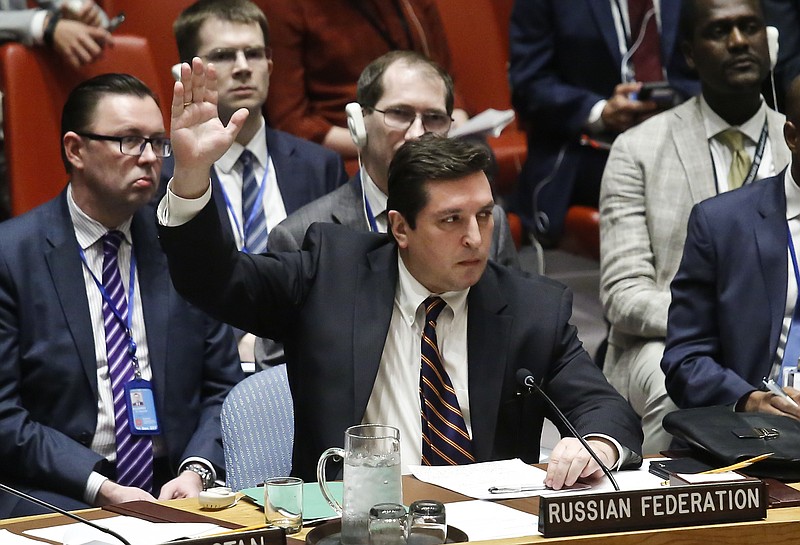 Russian Deputy U.N. Ambassador Vladimir Safronkov shows his hand to vote against a resolution condemning Syria's use of chemical weapons, Wednesday, April 12, 2017, at U.N. headquarters. (AP Photo/Bebeto Matthews)