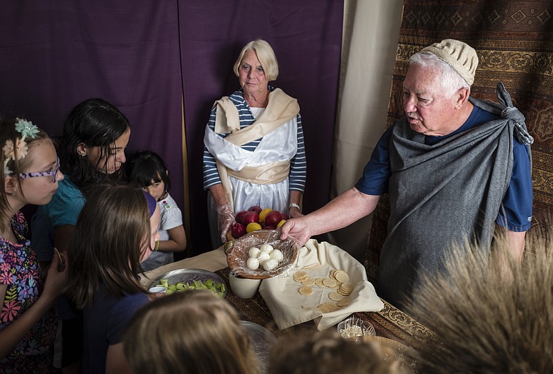 James LaMance, right, and Helen LaMance pass out food as they explain its significance to Passover at a "Road to Resurrection" event held at Red Bank Cumberland Presbyterian Church on Saturday, April 8, 2017, in Red Bank, Tenn. The Easter event took visitors through live scenes where actors explained the crucifixion and resurrection of Christ.