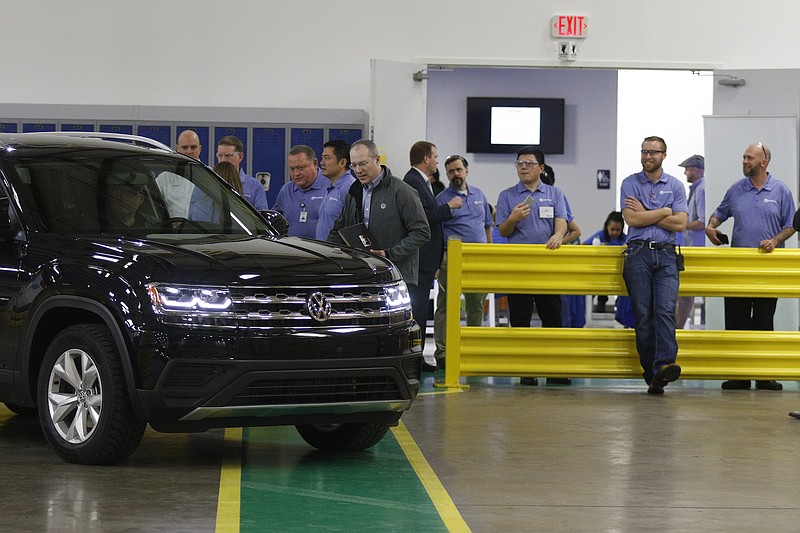 Workers watch as a new Volkswagen Atlas is parked for display at the new Yanfeng Automotive Interiors manufacturing plant in Chattanooga earlier this year.
