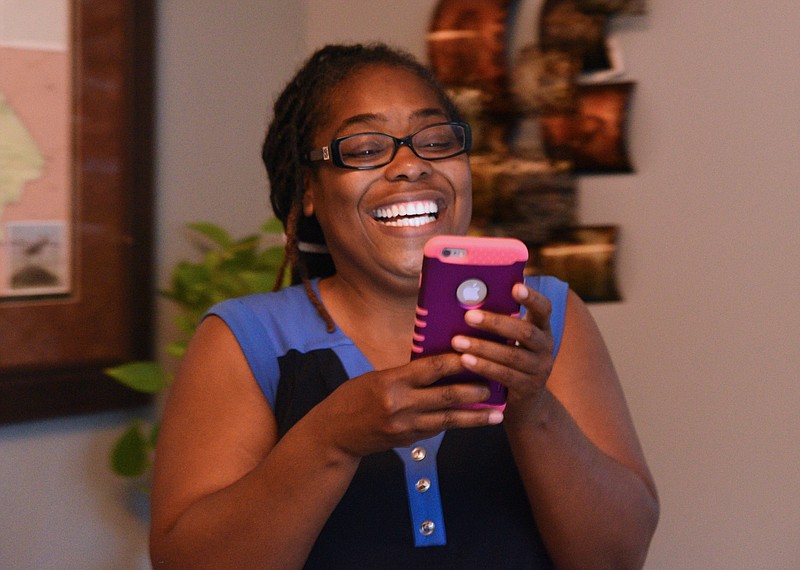 Demetrus Coonrod reads on her smartphone election returns of her win in a runoff election last Tuesday over incumbent City Councilman Yusuf Hakeem.