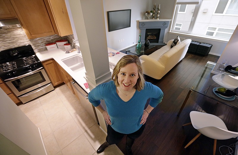 In this Thursday, March 30, 2017, photo, Kathleen Mulcahy stands in her recently sold one-bedroom condo, on which she received nearly two dozen offers and sold for more than $100,00 over her asking price, in Seattle's Belltown neighborhood. Many would-be buyers, especially in the big cities, will be wading into a market that's crowded with rival buyers and constrained by the lowest inventory of homes for sale in nearly two decades. That severe imbalance between supply and demand favors sellers, but also gives homeowners little incentive to part with their properties. (AP Photo/Elaine Thompson)