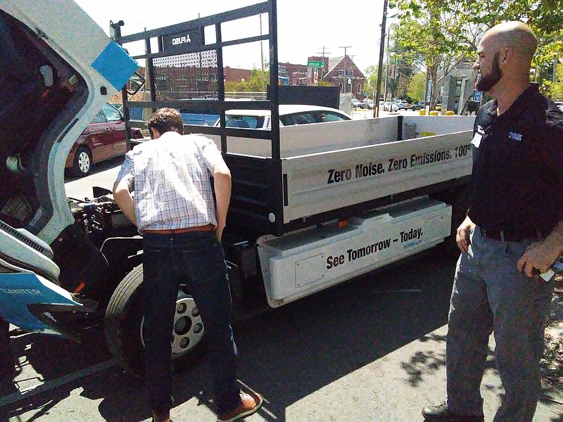 Michael Walton, left,executive director of Green Spaces and Mike Holtzhower, in market ing and servicing at Southeast Diesel Inc., look over a prototype all-electric work truck made by Mitsubishi Fuso Truck and Bus Corp. Thursday in a parking lot near East Main Street.