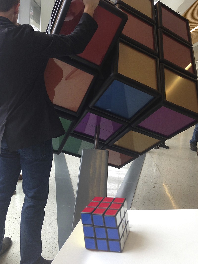 
              A traditional Rubik’s Cube sits on a podium in the foreground while a person operates an oversized version shortly after its unveiling inside the University of Michigan’s G.G. Brown engineering building in Ann Arbor, Mich., Thursday, April 13, 2017. Some of the past and present mechanical engineering students designed and built the 1,500-pound tribute to one of the world’s all-time great brain teasers. (AP Photo/Mike Householder)
            