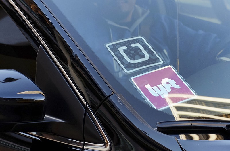 
              FILE - In this Jan. 12, 2016, file photo, a driver displaying Lyft and Uber stickers on his front windshield drops off a customer in downtown Los Angeles. A new report says Uber used a secret program dubbed "Hell" to track Lyft drivers to see if they were driving for both ride-hailing services and otherwise stifle competition. A representative for Uber did not respond to messages for comment Thursday, April 13, 2017. (AP Photo/Richard Vogel, File)
            