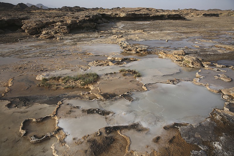 
              This March 5, 2017 photo shows travertine pools with white films of carbon fused with calcium, a chemical process being explored by a geological research project, in the al-Hajjar mountains of Oman. Deep in the jagged red mountains, geologists from the Oman Drilling Project are drilling in search of the holy grail of reversing climate change: an efficient and cheap way to remove carbon dioxide from the air and oceans. They are coring samples from one of the world's only exposed sections of the Earth’s mantle to uncover how a spontaneous natural process millions of years ago transformed CO2 into limestone and marble. (AP Photo/Sam McNeil)
            