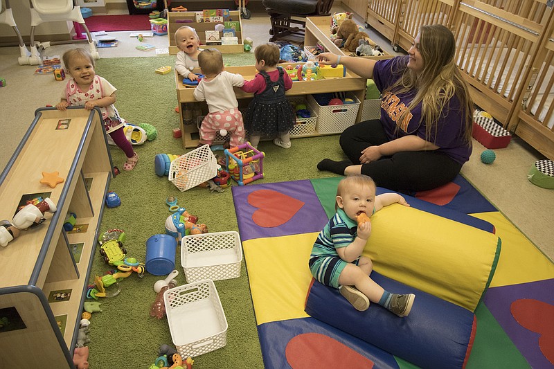 Hannah Salt works with the "Canaries", 8-14 month olds, while at Little Miss Mag on Thursday, April 13, 2017. The early learning center celebrates its 100th anniversary in business this month.