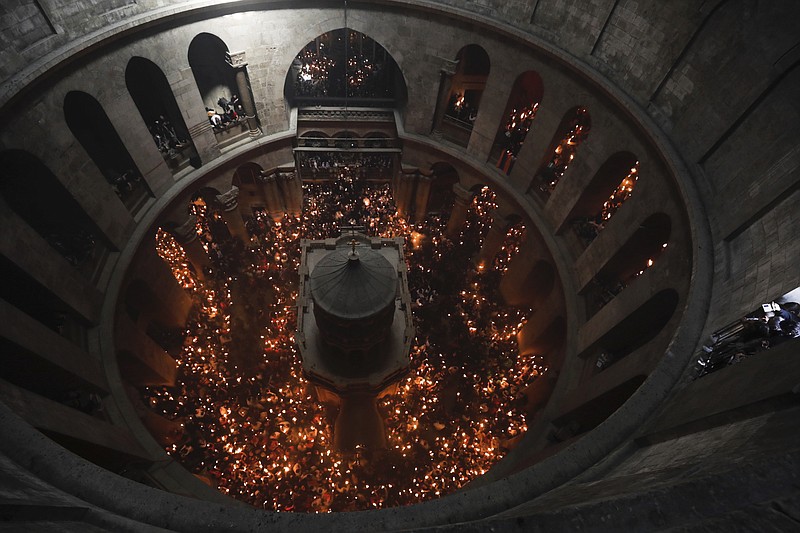 
              Christian pilgrims light candles during the Holy Fire ceremony in the church of the Holy Sepulchre, traditionally believed to be the burial site of Jesus Christ, Saturday, April 15, 2017, in Jerusalem. Thousands of Christians have gathered in Jerusalem for the ancient fire ceremony that celebrates Jesus' resurrection. (AP Photo/Tsafrir Abayov)
            