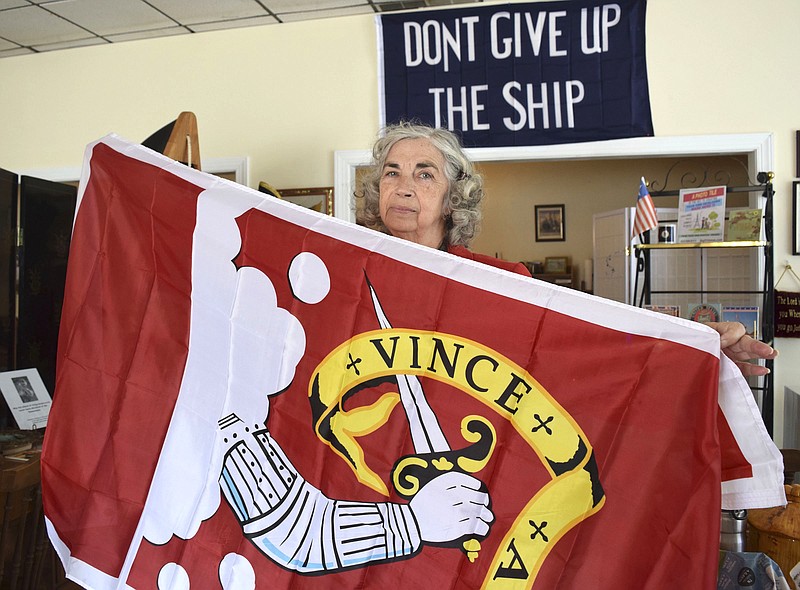 Conservative political activist and minister June Griffin holds a "Vince Aut Morire" (Conquer or Die) flag at her store in Dayton, Tenn., on Wednesday. Griffin vehemently opposes the planned installation of a statue of Scopes Trial lawyer Clarence Darrow on the lawn of the Rhea County Courthouse.