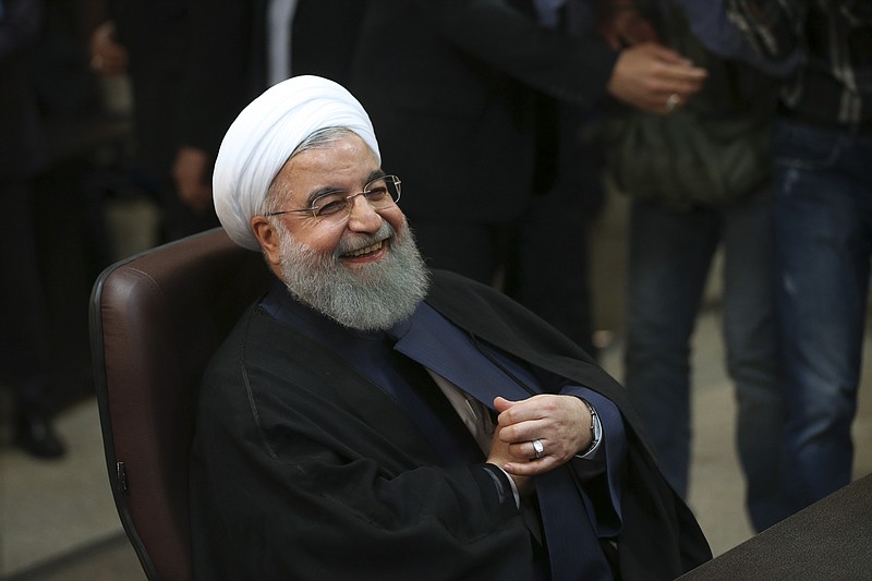 
              FILE- In this Friday, April 14, 2017 file photo, Iranian President Hassan Rouhani smiles as he attends at the Interior Ministry to register his candidacy for the May 19 presidential elections, in Tehran, Iran. Over 1,600 people registered to run. Under Iranian law, there's no fee for registering. Hopefuls only must believe in Iran's form of government and be Shiite Muslims. (AP Photo/Vahid Salemi, File)
            