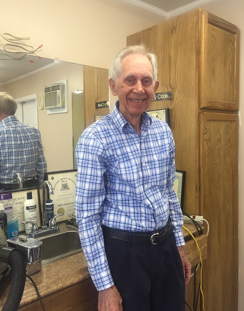 Larry Cook stands at his station in the Lee Highway Barber and Style Shop, where he still works each Tuesday, Wednesday and Thursday.