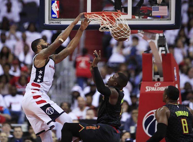 
              Washington Wizards forward Markieff Morris (5) dunks the ball while Atlanta Hawks forward Paul Millsap (4) and Dwight Howard (8) watch during the second half in Game 1 of a first-round NBA basketball playoff series, in Washington, Sunday, April 16, 2017. The Wizards won 114-107. (AP Photo/Manuel Balce Ceneta)
            