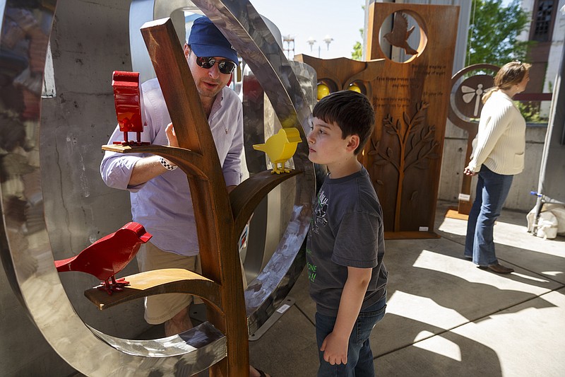 Chris Smith and his son, Carter, check out sculpture at the 2016 4 Bridges Arts Festival.