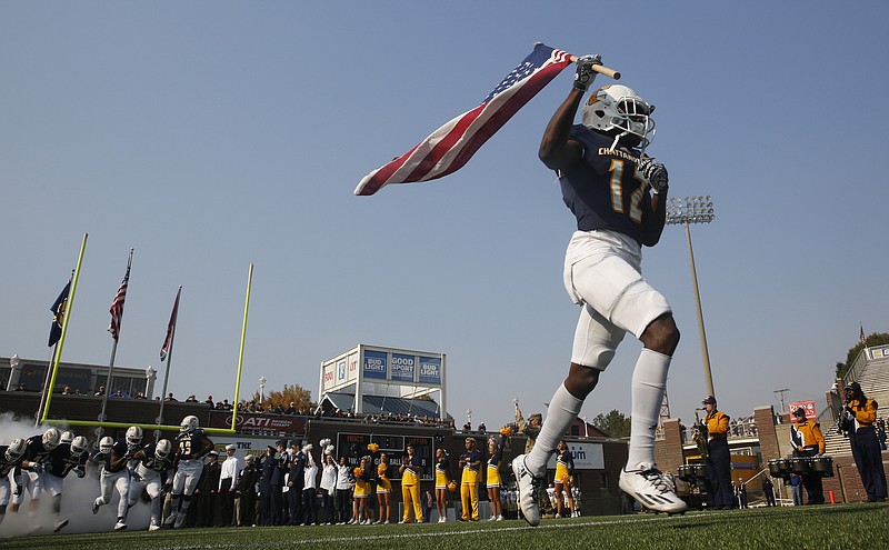 UTC wide receiver Xavier Borishade carries an American flag onto the field ahead of the team during a Mocs' home football game against Wofford last November.