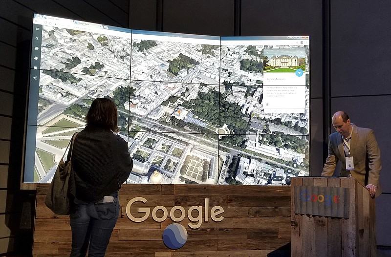 
              Sean Askay, right, engineering manager with Google Earth, demonstrates features on Google Earth, displayed in background, Tuesday, April 18, 2017, in New York. Google Earth is getting a revival, with the mapping service becoming more of a tool for adventure and exploration. (AP Photo/Anick Jesdanun)
            