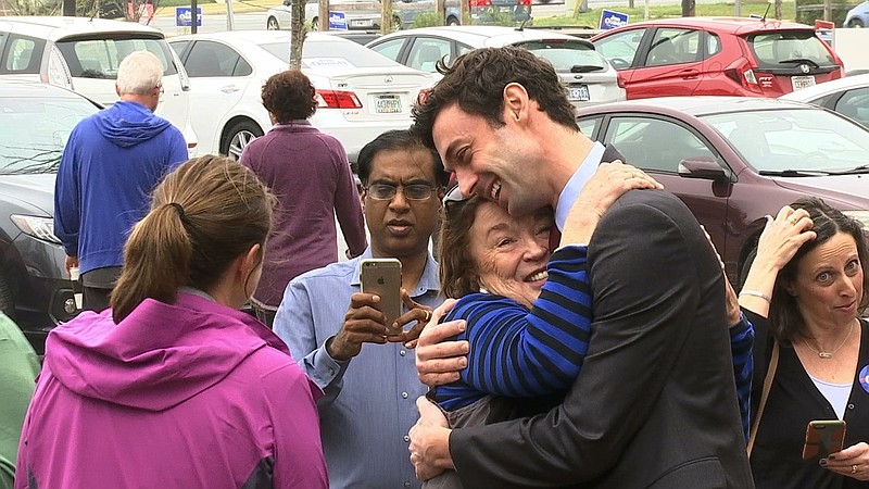 
              In a Monday, March 27, 2017 photo, Democratic Congressional candidate Jon Ossoff greets supporters outside of the East Roswell Branch Library in Roswell, Ga., on the first day of early voting. President Donald Trump is attacking the leading Democratic candidate for a special election in a typically conservative Georgia congressional district, with Republicans bidding to avoid a major upset. On Twitter, Trump said Monday April 17, 2017, that "The super Liberal Democrat in the Georgia Congressional race tomorrow wants to protect criminals, allow illegal immigration and raise taxes!" (AP Photo/Alex Sanz)
            