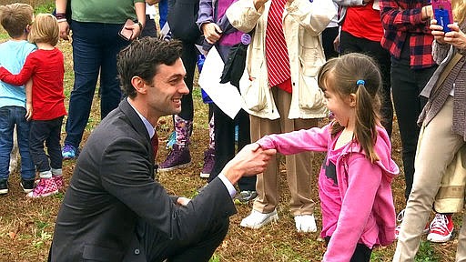 In a Monday, March 27, 2017 photo, Democratic congressional candidate Jon Ossoff is seen with supporters outside of the East Roswell Branch Library in Roswell, Ga., on the first day of early voting. President Donald Trump is attacking Ossoff, the leading Democratic candidate for a special election in a typically conservative Georgia congressional district, with Republicans bidding to avoid a major upset. On Twitter, Trump said Monday April 17, 2017, that "The super Liberal Democrat in the Georgia Congressional race tomorrow wants to protect criminals, allow illegal immigration and raise taxes!" (AP Photo/Alex Sanz)