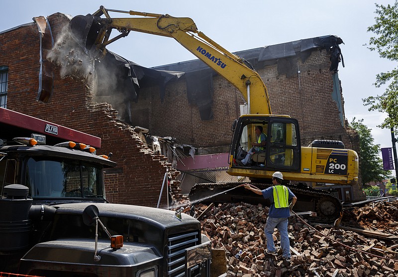 Workers demolish the Market Street building which housed the Cheeburger Cheeburger restaurant on Wednesday, April 19, 2017, in Chattanooga, Tenn.