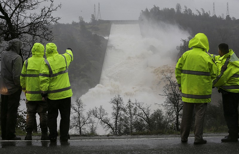 
              FILE - In this Feb. 9, 2017, file photo, water rushes down the damaged Oroville Dam spillway, in Oroville, Calif. Over six days, operators of the tallest dam in the United States, struggled to figure out their next move after raging floodwaters from California's wettest winter in decades gouged a hole the size of a football field in the dam's main water-release spillway. (AP Photo/Rich Pedroncelli, File)
            