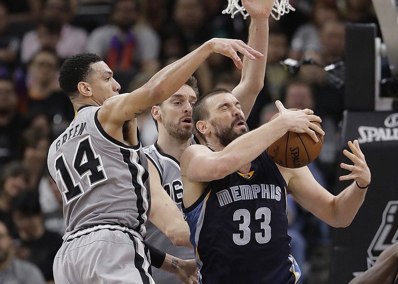 
              FILE - In this April 15, 2017, file photo, Memphis Grizzlies center Marc Gasol (33) is defended by San Antonio Spurs guard Danny Green (14) and center Pau Gasol during the second half in Game 1 of a first-round NBA basketball playoff series, in San Antonio. Pau and Marc Gasol have been battling each other on a basketball court since they were children with the older brother always finding ways to win. Now little brother Marc is doing his best to rally the Grizzlies to avoid being swept away in their first playoff meeting.  (AP Photo/Eric Gay, File)
            