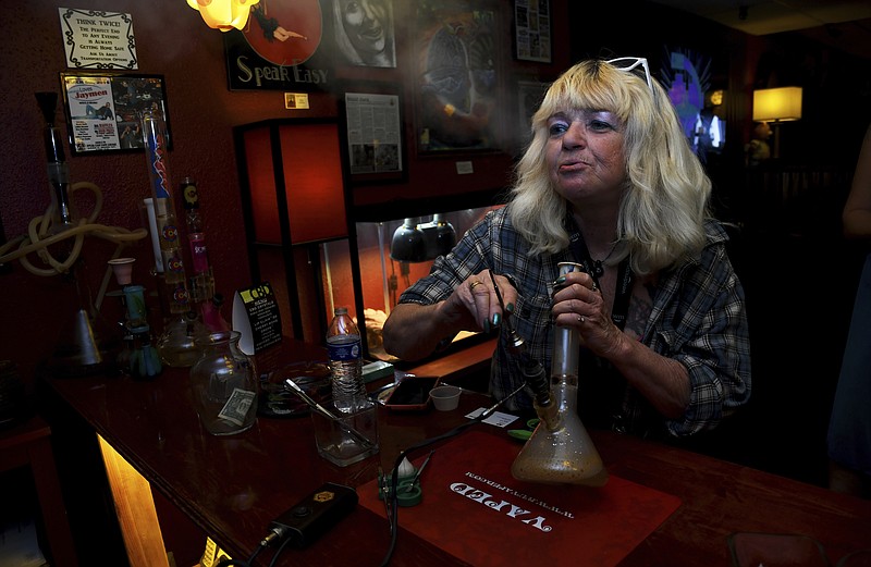 
              In this April, 12, 2017 photo, Linda Wood smokes a concentrated form of marijuana called a "dab" at the Speakeasy Vape Lounge, one of the United States' only legal pot clubs, in Colorado Springs, Colo. Wood started using marijuana for pain relief after a hip-replacement surgery. She joined the club because her apartment does not allow marijuana use. (AP Photo/Thomas Peipert)
            