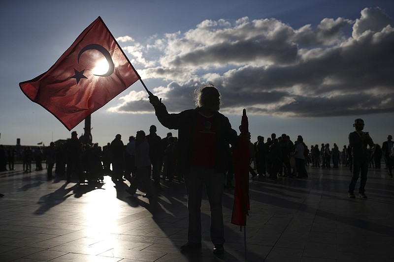 
              A supporter of the 'no' vote, holds a Turkish flag during a protest regarding Sunday's referendum outcome, on the Aegean Sea city of Izmir, Turkey, Tuesday, April 18, 2017.  Turkey's main opposition party has filed a formal request seeking Sunday's referendum to be annulled because of alleged voting irregularities. (AP Photo/Emre Tazegul)
            