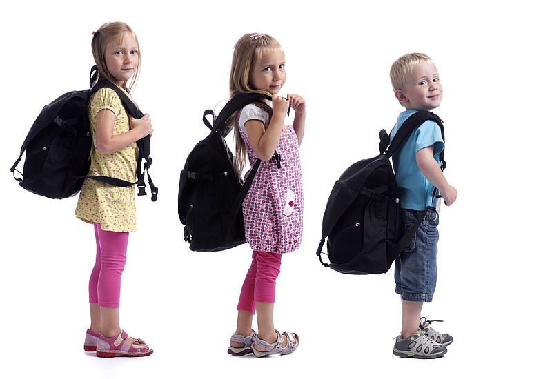 childeren in a row with backpacks. Isolated on white background