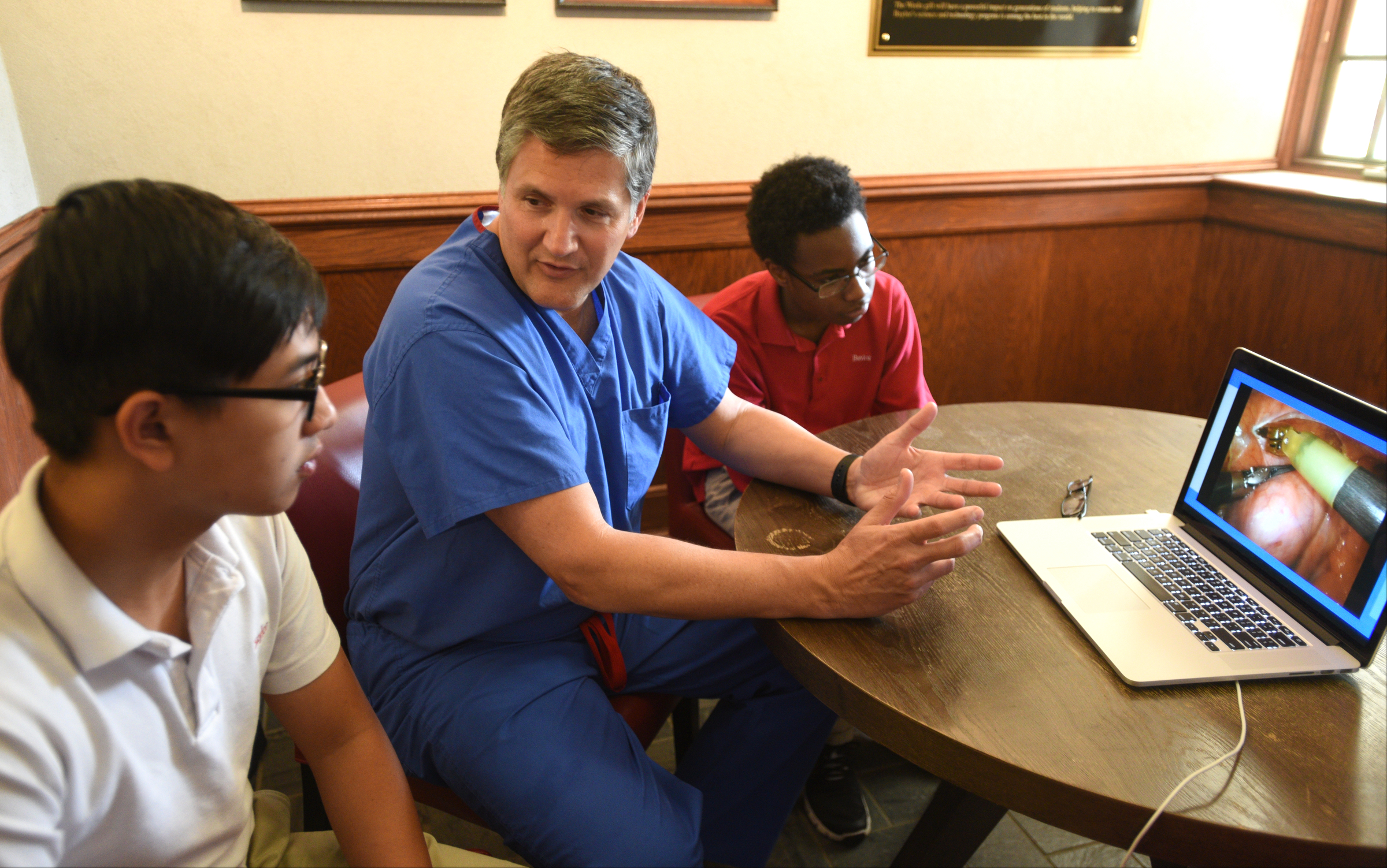 Dr. Rob Headrick, center, cardiothoracic surgeon with CHI Memorial, talks with Jacky Li, left, and Nicholas Daniels Thursday, April 20, 2017 at Baylor. Students had the opportunity to sit at the controls of the da Vinci Surgical System.