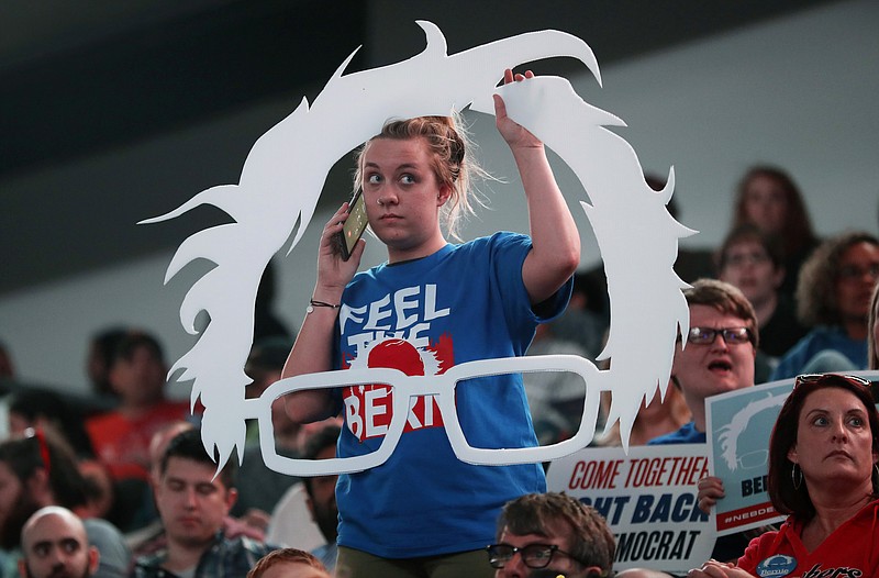 Carly Hein of Omaha, Neb., talks on her cell phone as she waits for Sen. Bernie Sanders, I-Vt., to arrive at a rally for Omaha Democratic mayoral candidate Heath Mello, Thursday, April 20, 2017, in Omaha, Neb. Sanders, who attracted millions of college-aged and young adults to his presidential campaign last year, is following through on what he said in leaving the 2016 presidential race last year was the Democratic Party's chief responsibility, to welcome younger leaders into its ranks. (AP Photo/Charlie Neibergall)