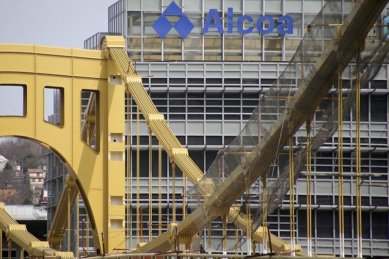 
              FILE – This April 3, 2017, file photo, shows the Alcoa Corporate Center behind the Seventh Street Bridge, also known as the Andy Warhol Bridge, in Pittsburgh. Alcoa Corp. is moving its global headquarters back to Pittsburgh, the 129-year-old aluminum producer announced Wednesday, April 19, 2017, relocating 10 employees from New York City, designated as the company's principal office in 2006. (AP Photo/Keith Srakocic, File)
            