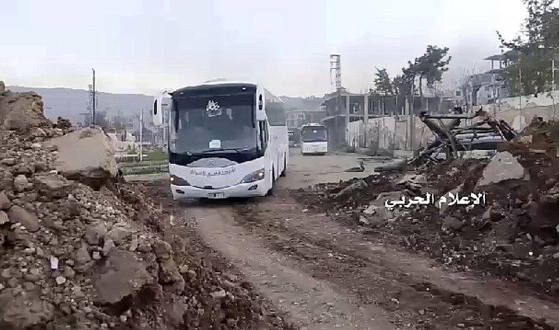 
              This frame grab from video provided by the government-controlled Syrian Central Military Media, shows buses carrying opposition fighters leaving Zabadani, near Damascus, Syria, Wednesday, April. 19, 2017, heading toward the northern rebel-held Idlib province. Syria's military media says the evacuation and transfer of thousands of Syrians from four besieged areas has resumed. Logo in Arabic reads, "Millitary Media."  (Syrian Central Military Media, via AP)
            