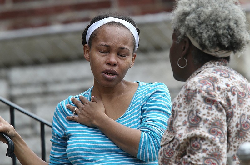 
              CORRECTS FIRST NAME TO MANYIKA  Manyika McCoy, left, cries while she talks to her mother Alice Spann, Thursday, April 20, 2017, in St. Louis. McCoy had just been talking to two Laclede Gas Co. workers just before they were killed by a man who walked up and started shooting. (J.B. Forbes/St. Louis Post-Dispatch via AP)
            