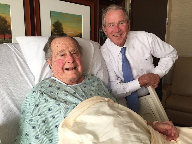 
              This Thursday, April 20, 2017, photo provided by the Office of George H.W. Bush shows former President George H.W. Bush, left, posing with his son former President George W. Bush at Houston Methodist Hospital in Houston where he is recovering from a mild case of pneumonia. He was admitted to the hospital Friday, April 14 for treatment of a persistent cough and doctors determined he had pneumonia. (Evan Sisley/Office of George H.W. Bush via AP)
            