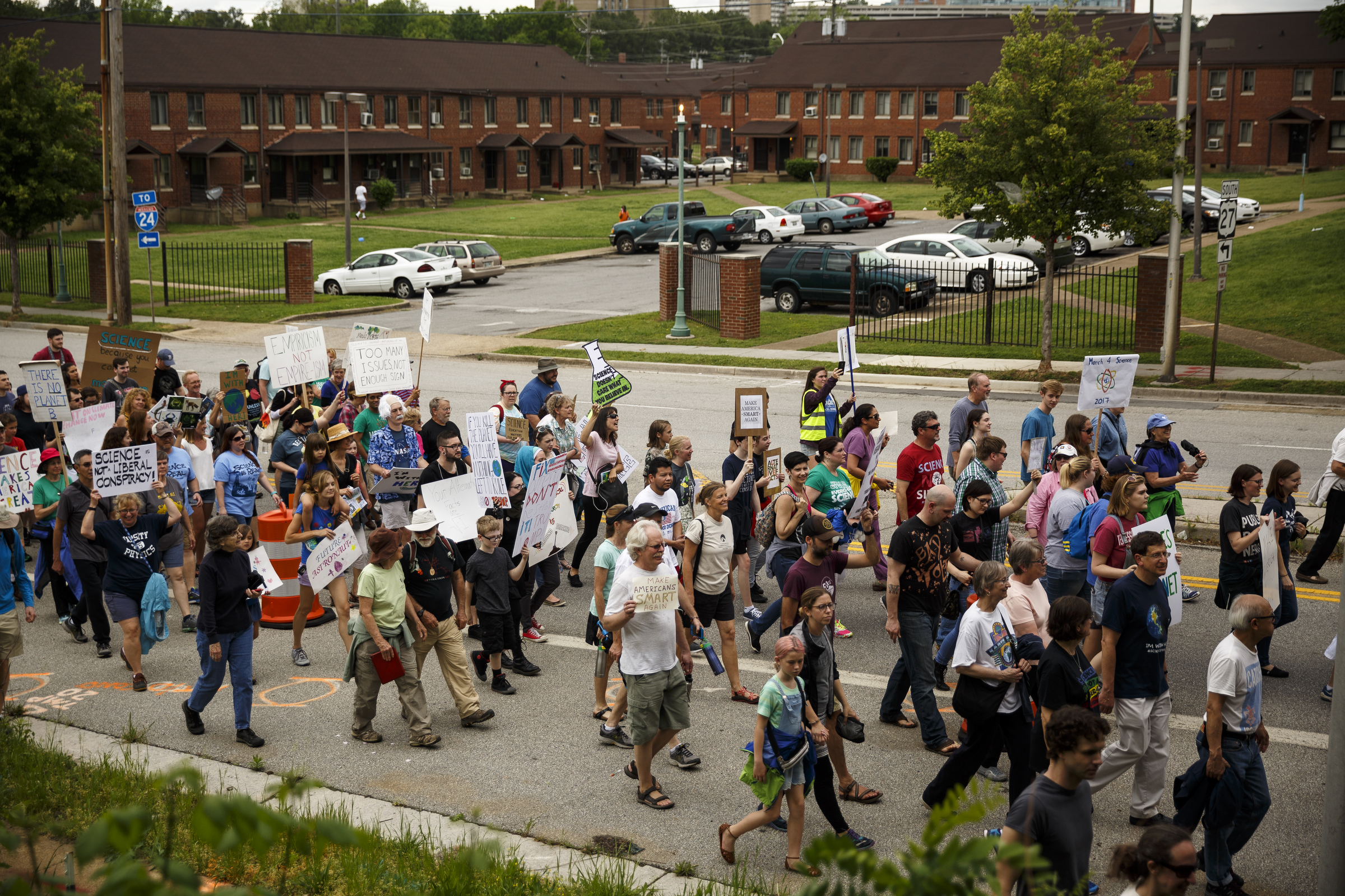 Demonstrators pass College Hill Courts on Main Street during the March for Science on Saturday, April 22, 2017, in Chattanooga, Tenn. About a thousand demonstrators marched from the Main Terrain Art Park to Riverfront Parkway and back in support of science and education in solidarity with other marches nationwide.