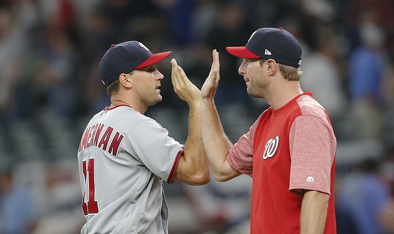 
              Washington Nationals first baseman Ryan Zimmerman (11), left, celebrates with pitcher Max Scherzer (31) after the Nationals defeated the Atlanta Braves 3-2 in a baseball game Thursday, April 20, 2017, in Atlanta. Zimmerman hit a two-run home. Scherzer did not play. (AP Photo/John Bazemore)
            