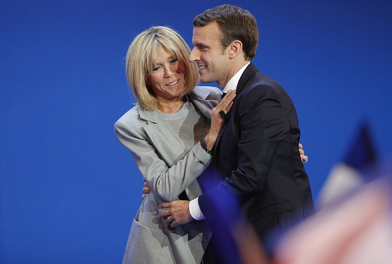 
              French centrist presidential candidate Emmanuel Macron and his wife Brigitte hug as he addresses his supporters at his election day headquarters in Paris , Sunday April 23, 2017. Macron and far-right populist Marine Le Pen advanced Sunday to a runoff in France's presidential election, remaking the country's political system and setting up a showdown over its participation in the European Union. (AP Photo/Christophe Ena)
            
