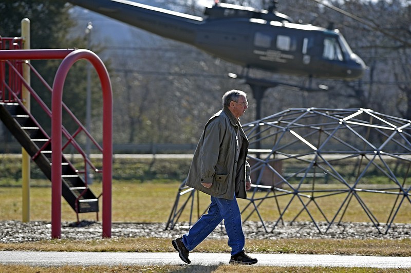 Jerry Cline walks past the playground as he uses the walking track at Soddy-Daisy Veterans Park, one of several parks where the city plans to install cameras. In the background is a Vietnam-era helicopter on display in the park.
