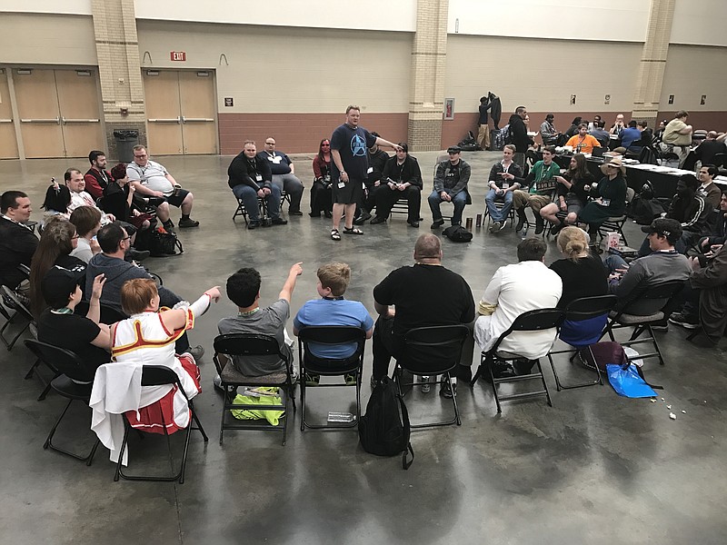 Both Infinity Flux and Game On participated at 2017's Con Nooga, assisting with the convention's board game room. Here, a large game of Werewolf, a social party game, is played by over two dozen people.