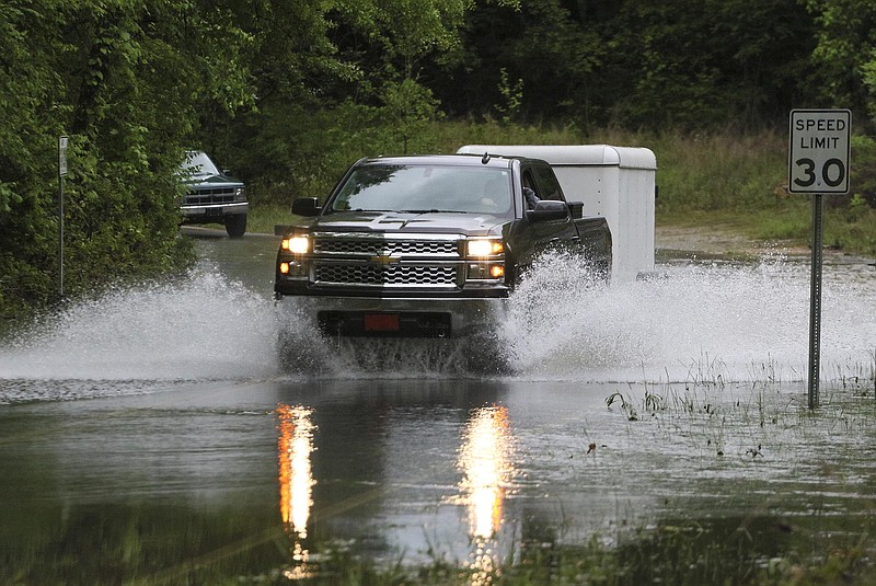 Staff Photo by Dan Henry / The Chattanooga Times Free Press- 4/24/17. Motorists drive through standing water on Sandswitch Road near Boy Scout Rd. after recent rains flood the area on Monday, April 24, 2017. 