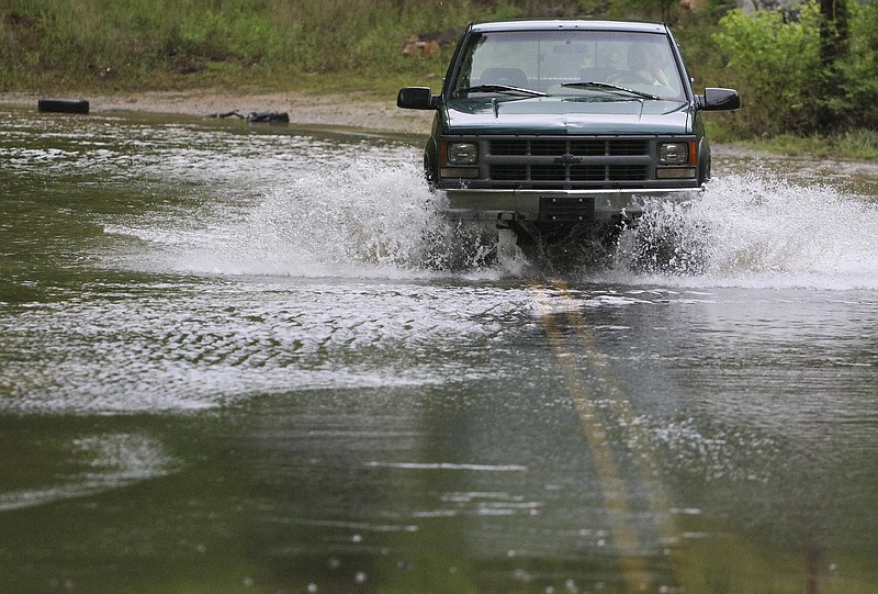 Staff Photo by Dan Henry / The Chattanooga Times Free Press- 4/24/17. Motorists drive through standing water on Sandswitch Road near Boy Scout Rd. after recent rains flooded the area on Monday, April 24, 2017. 