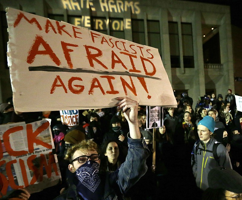 
              FILE - In this Jan. 20, 2017 photo, a protester holds a sign that reads "Make Fascists Afraid Again!" during a demonstration in front of Kane Hall on the University of Washington campus where far-right commentator Milo Yiannopoulos was giving a speech in Seattle. Prosecutors charged a couple Monday, April 24, 2017 in connection with a shooting earlier in the evening during the protest. (AP Photo/Ted S. Warren, file)
            