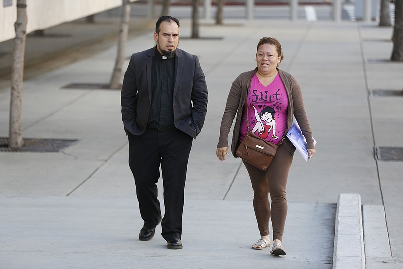 
              In this Thursday, March 30, 2017, photo the Rev. Francisco Garcia, left, escorts Carmen Cardona, a Honduran immigrant, to an Immigration and Customs Enforcement appointment in downtown Los Angeles. Volunteers are stepping up to accompany people living in the United States illegally to court hearings and meetings with immigration officials in New York, New Mexico and elsewhere, with the goal of guiding them through what’s often an intimidating process. (AP Photo/Damian Dovarganes)
            