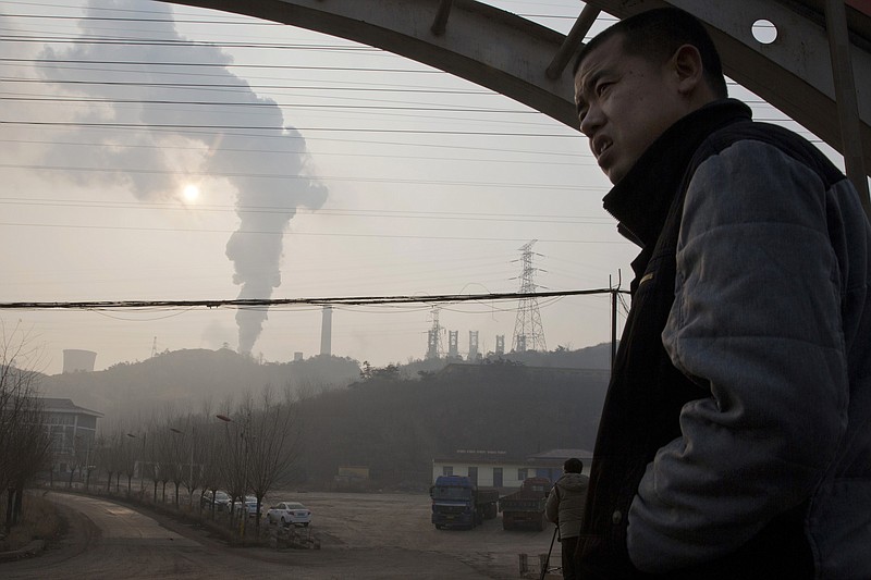 
              FILE - In this Dec. 30, 2016 file photo, a man looks up near smoke spewing from a chimney near the Jiujiang steel and rolling mills in Qianan in northern China's Hebei province. Researchers say Tuesday, April 25, 2017 that China's conversion of coal into natural gas could prevent tens of thousands of premature deaths annually. But there's a catch: It also could undermine efforts to rein in greenhouse gas emissions. (AP Photo/Ng Han Guan, File)
            