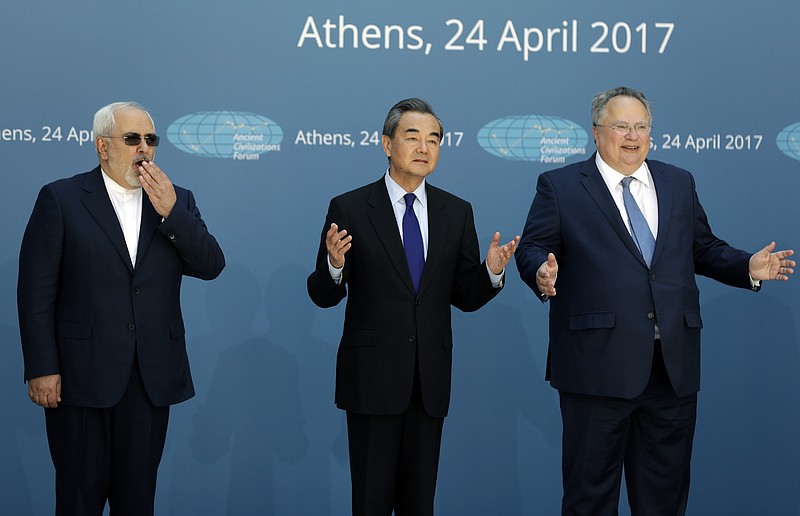 
              Greek Foreign Minister Nikos Kotzias, right, and his Iranian counterpart Mohammad Javad Zarif, left, and Chinese Foreign Minister Wang Yi gesture as they pose for the photographers as they attend the "Ancient Civilizations Forum" (ACForum) at Zappeio Conference Hall in Athens, Monday, April 24, 2017. Foreign Ministers and top officials from various countries attended the forum being held in the Greek capital. (AP Photo/Thanassis Stavrakis)
            