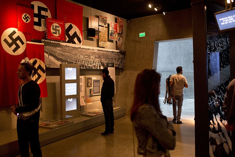 
              People look at an exhibit as they tour the Yad Vashem Holocaust Memorial Jerusalem, Sunday, April 23, 2017. Israel is marking the annual Holocaust Remembrance Day beginning at sunset Sunday. (AP Photo/Oded Balilty)
            