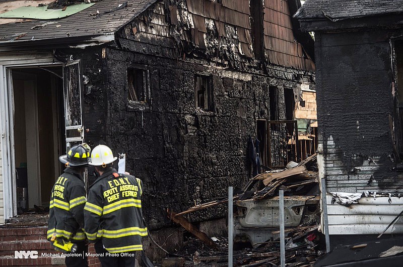 
              New York Fire Department personnel stand outside the scene of a deadly fire Sunday, April 23, 2017, in Queens Village in New York that killed multiple people, including children. The fire broke out Sunday afternoon on a street full of single-family homes in the middle class neighborhood of Queens Village.  (Michael Appleton/Office of the Mayor via AP)
            