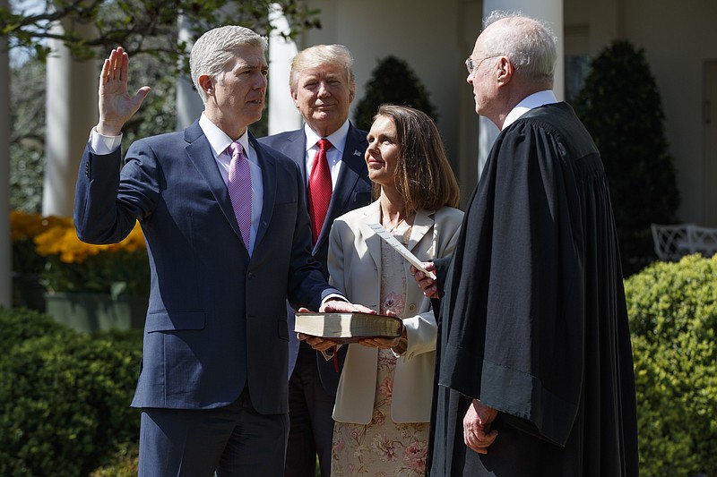 
              FILE - In this April 10, 2017, file photo, President Donald Trump watches as Supreme Court Justice Anthony Kennedy administers the judicial oath to Judge Neil Gorsuch during a re-enactment in the Rose Garden of the White House, in Washington. Gorsuch's wife Marie Louise Gorsuch hold a bible. Republicans have put President Donald Trump's Supreme Court nominee on the bench, and they’re now in a position to fill dozens more federal judgeships and reshape some of the nation's highest courts. (AP Photo/Evan Vucci, File)
            