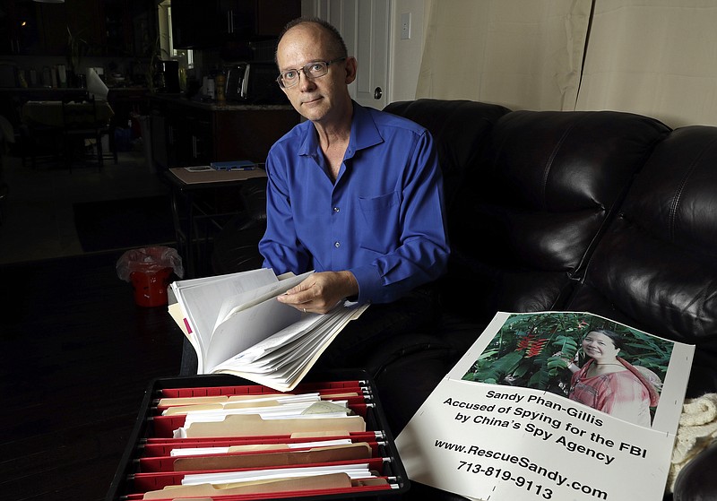 
              FILE - In this Oct. 4, 2016, file photo, Jeff Gillis looks through documents he has collected in support of his wife in Houston. The husband of U.S. citizen Phan "Sandy" Phan-Gillis, who has been charged in China with spying, has spent months trying to prove his wife's innocence with the little information he had. A Chinese court on Tuesday, April 25, 2017, sentenced Phan-Gillis to 3 ½ years in prison for spying charges, in a case that has drawn criticism from the United Nations and human rights advocates. (AP Photo/David J. Phillip, File)
            