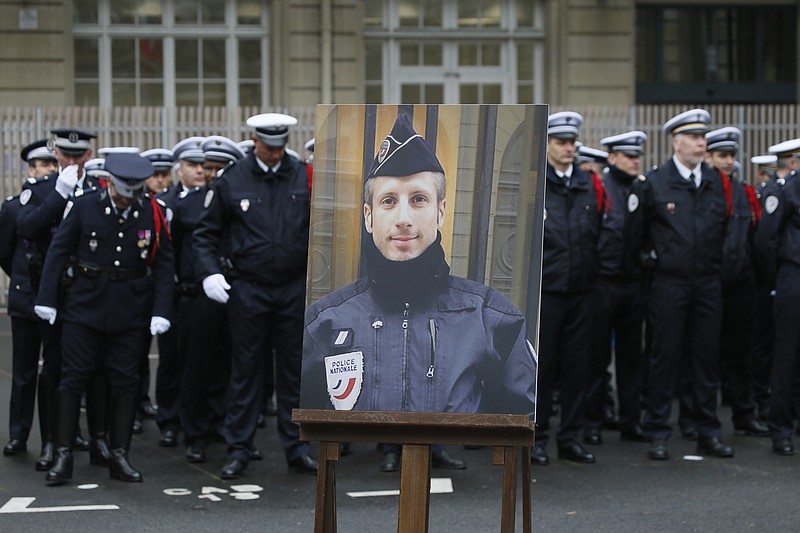 
              A portrait of killed police officer Xavier Jugele is seen in the courtyard of the Paris Police headquarters before an official homage, Tuesday, April 25, 2017. A gunman shot and killed Jugele on the famed Champs-Elysees just days before the firt round of the French presidential vote. (AP Photo/Francois Mori)
            